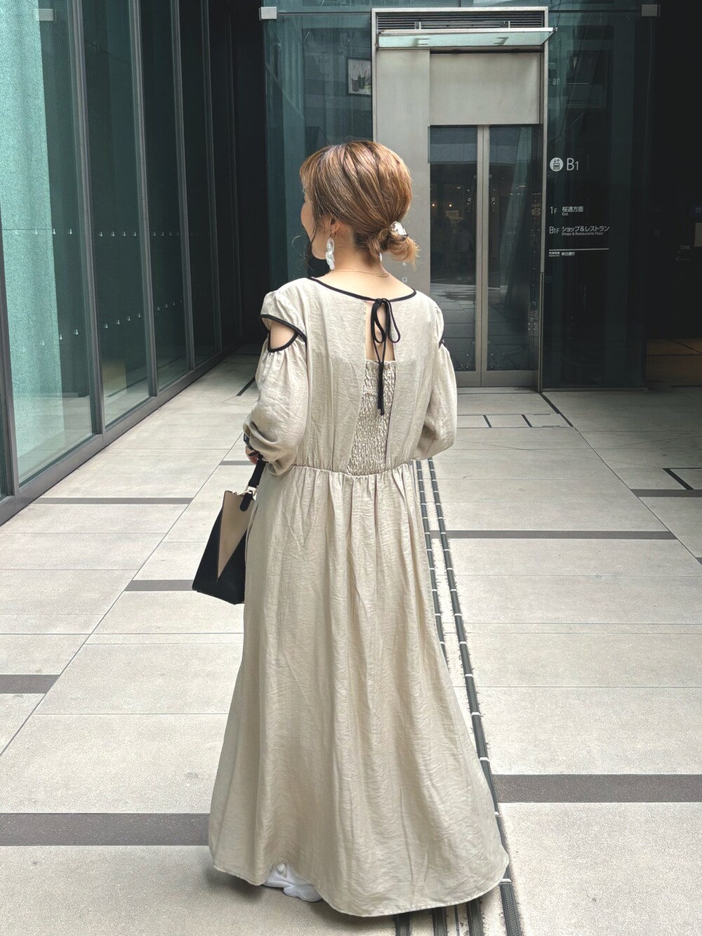 ベージュ系のワンピースを着用したレディースの夏コーディネートの2枚目の写真