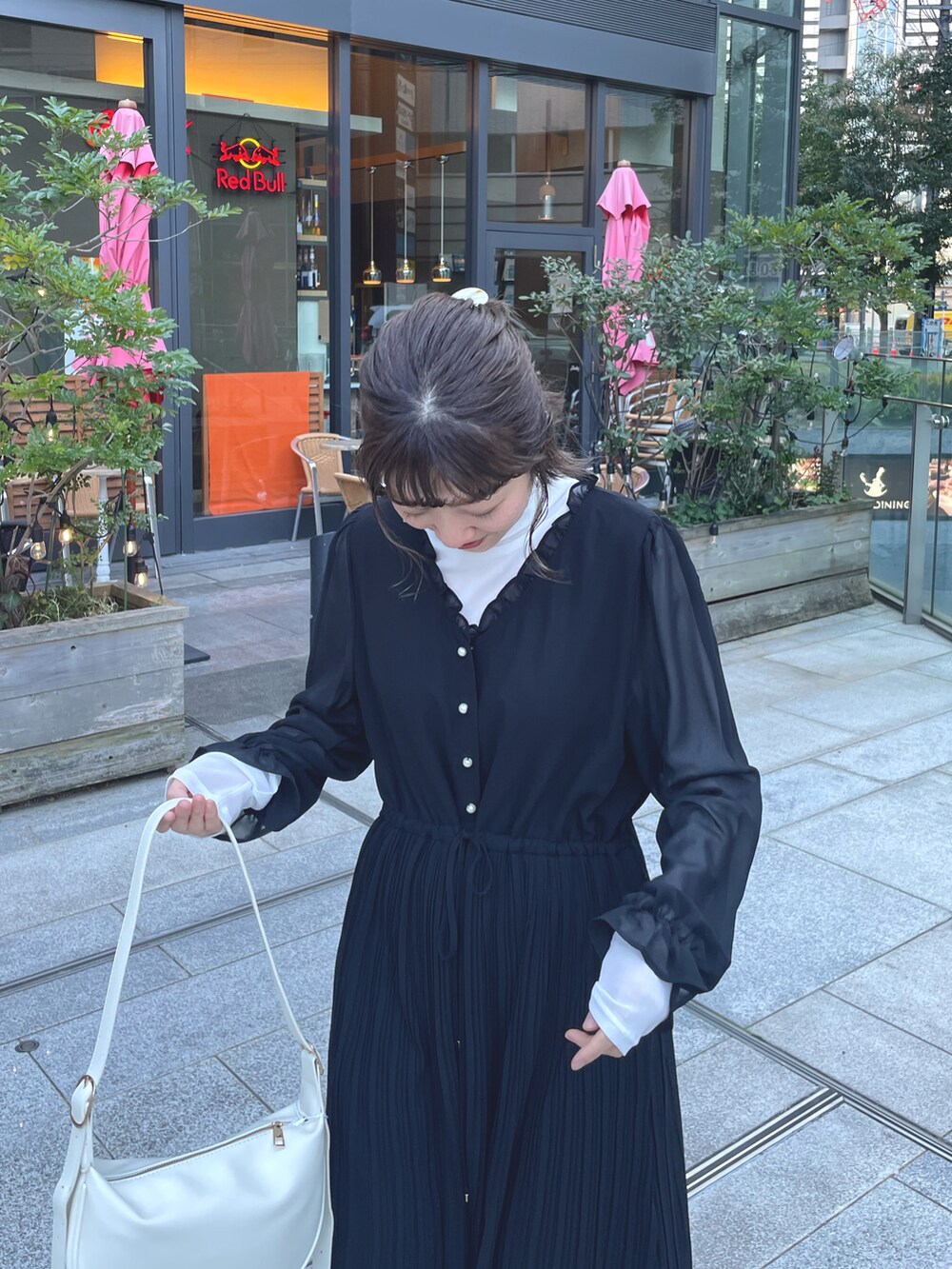 ブラック系のワンピース、ホワイト系のデニムジャケットを着用したレディースの冬コーディネートの5枚目の写真