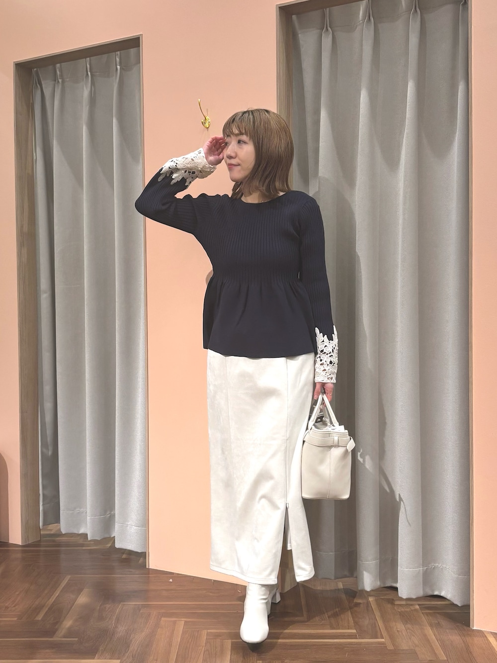 ブルー系のニット/セーター、ホワイト系のブーツ、ホワイト系のショルダーバッグを着用したレディースの冬コーディネートの3枚目の写真