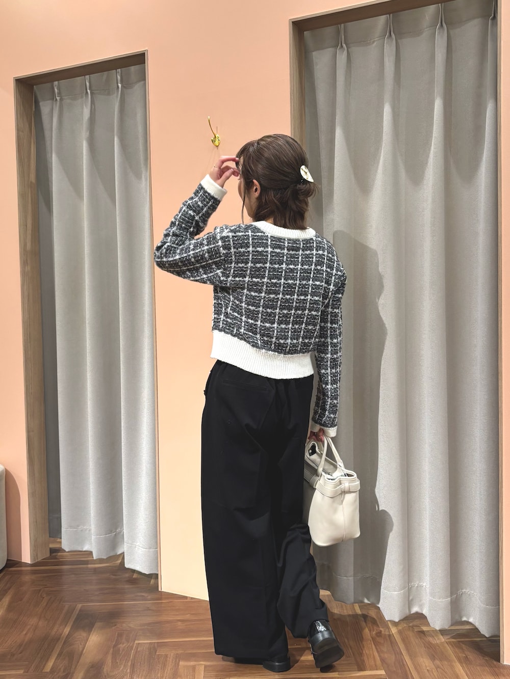 ブラック系のカーディガン/ボレロ、ブラック系のパンツ、ホワイト系のショルダーバッグを着用したレディースの秋コーディネートの2枚目の写真