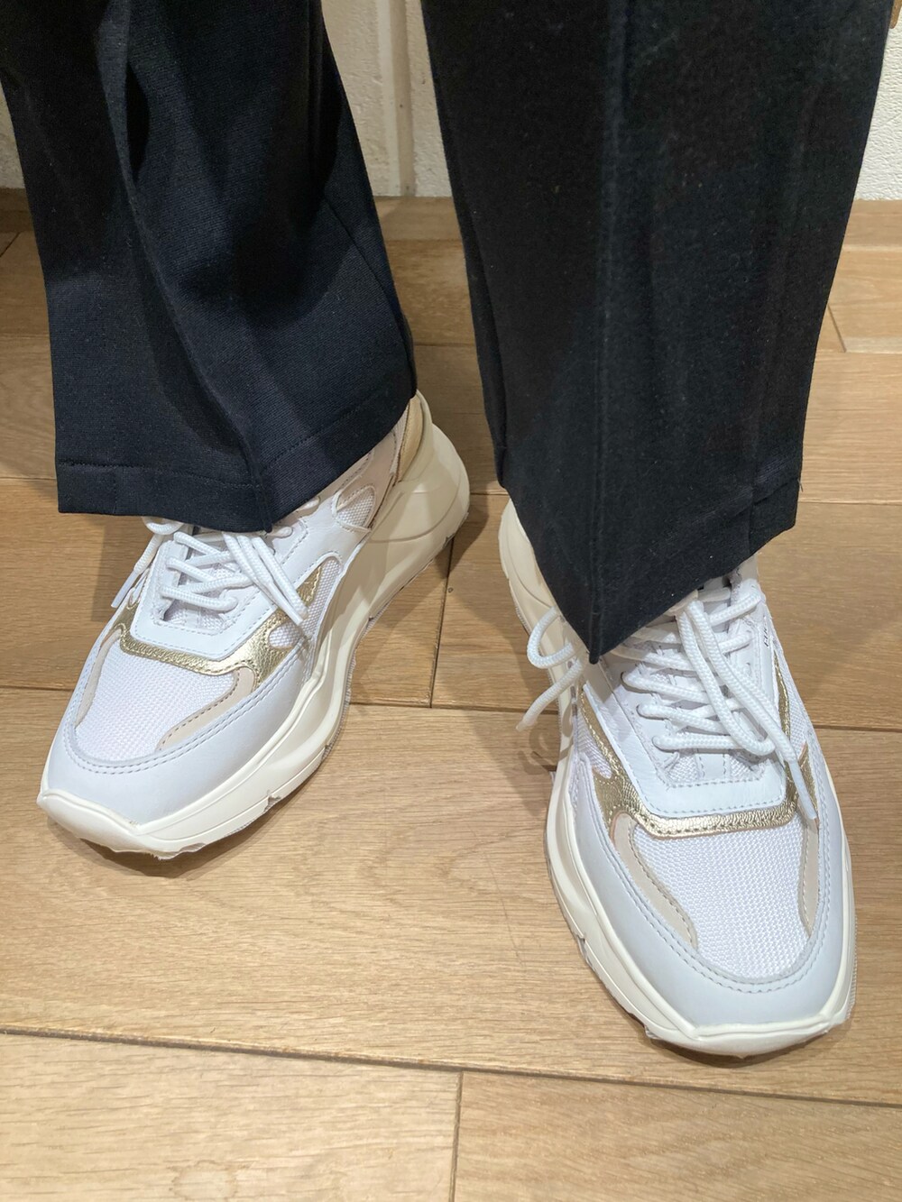 ホワイト系のニット/セーター、ベージュ系のベスト、ブラック系のパンツを着用したレディースの冬コーディネートの4枚目の写真