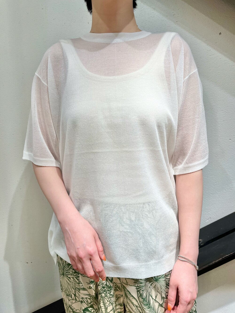 ホワイト系のニット/セーター、グリーン系のその他パンツ、ブラック系のサンダルを着用したレディースの夏コーディネートの4枚目の写真