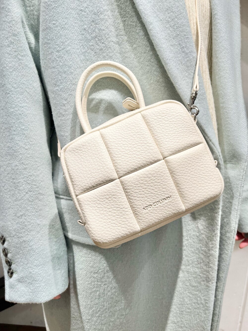 ホワイト系のハンドバッグ、ブルー系のジャケット/アウター、ブルー系のパンツを着用したレディースの冬コーディネートの2枚目の写真