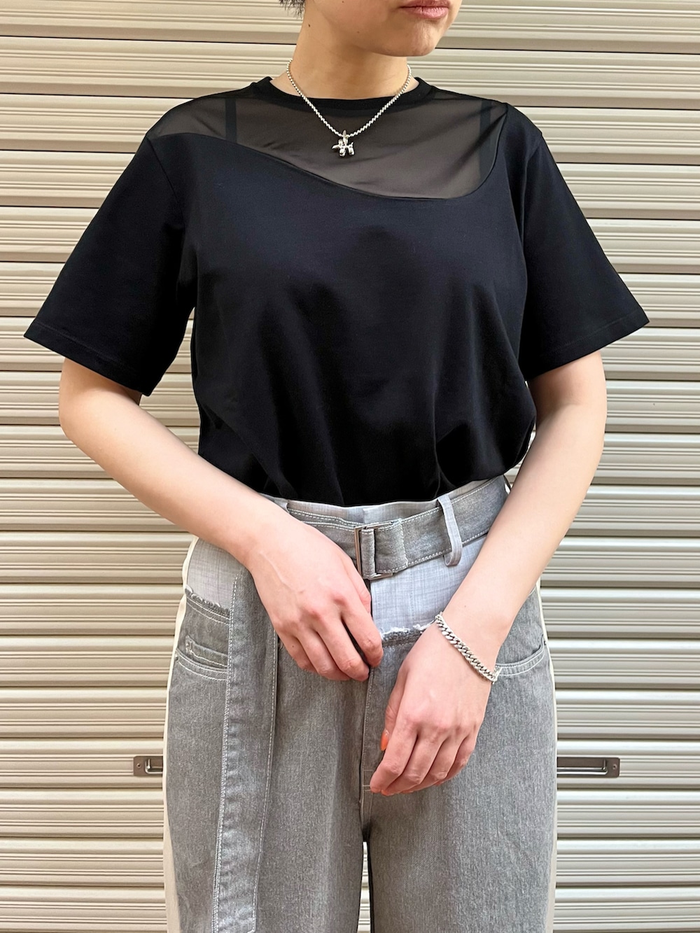 ブラック系のサンダル、グレー系のデニムパンツ、ブラック系のTシャツ/カットソーを着用したレディースの春コーディネートの5枚目の写真