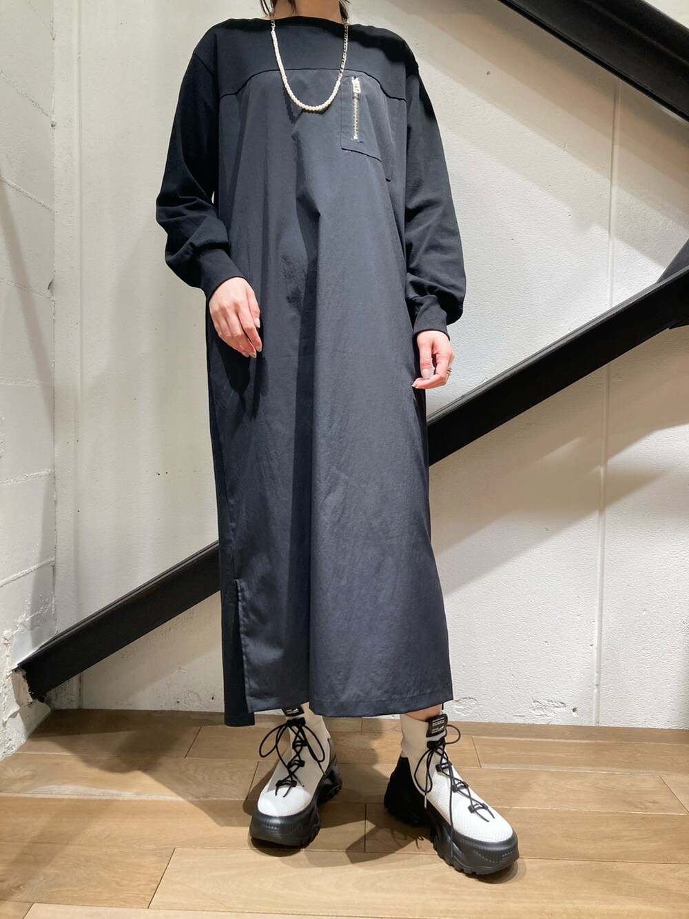 ホワイト系のカーディガン/ボレロ、ブラック系のワンピース、ホワイト系のスニーカーを着用したレディースの冬コーディネートの2枚目の写真