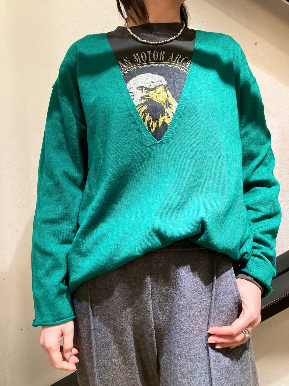 ブラック系のTシャツ/カットソー、グリーン系のニット/セーター、ベージュ系のトレンチコートを着用したレディースの冬コーディネートの3枚目の写真