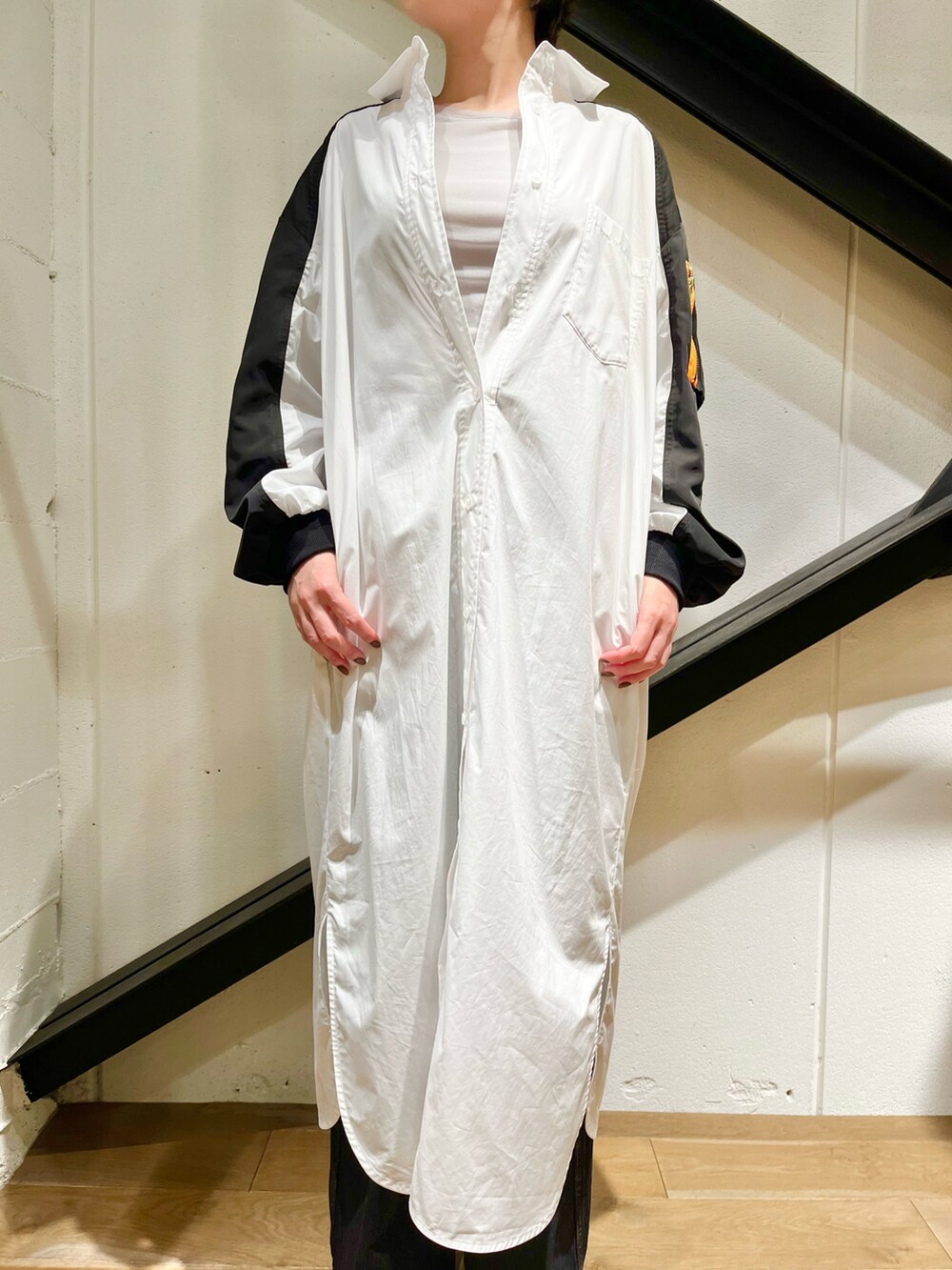 グレー系のスニーカー、ブラック系のハンドバッグを着用したレディースの秋コーディネートの2枚目の写真