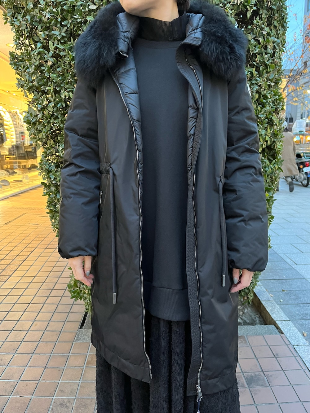 ブラック系のショルダーバッグ、ブラック系のワンピース、ブラック系のスニーカーを着用したレディースの冬コーディネートの3枚目の写真