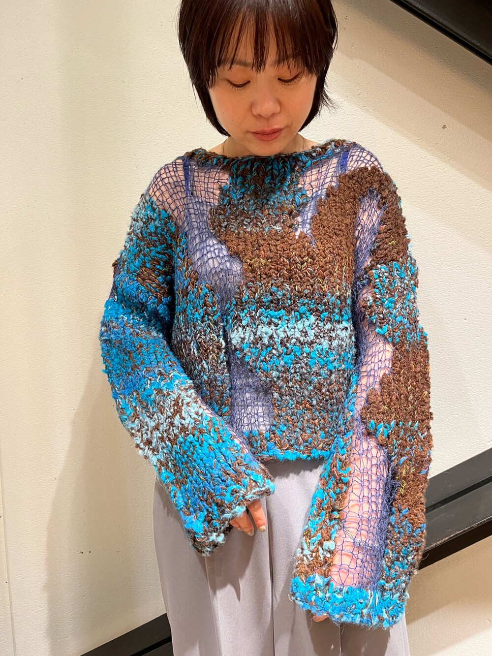 ベージュ系のMA-1、ブルー系のニット/セーター、グレー系のパンツを着用したレディースの秋コーディネートの4枚目の写真