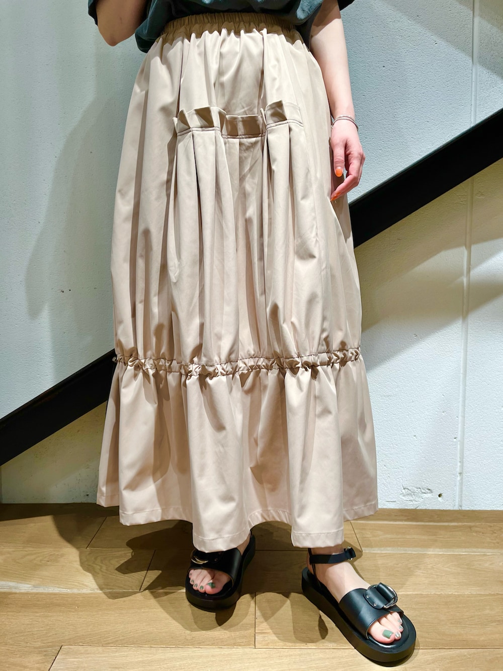 イエロー系のトートバッグ、グレー系のTシャツ/カットソー、ベージュ系のスカートを着用したレディースの夏コーディネートの4枚目の写真