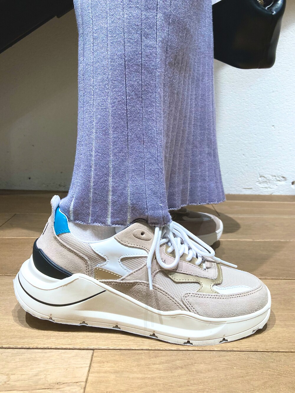 ブラック系のハンドバッグ、ブラック系のパーカー、グレー系のパンツを着用したレディースの春コーディネートの4枚目の写真