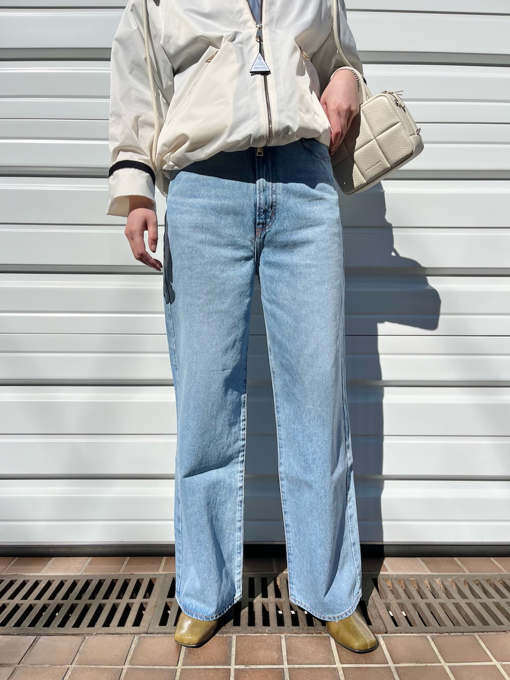 ホワイト系のハンドバッグ、その他のデニムパンツ、ホワイト系のジャケット/アウターを着用したレディースの春コーディネートの3枚目の写真