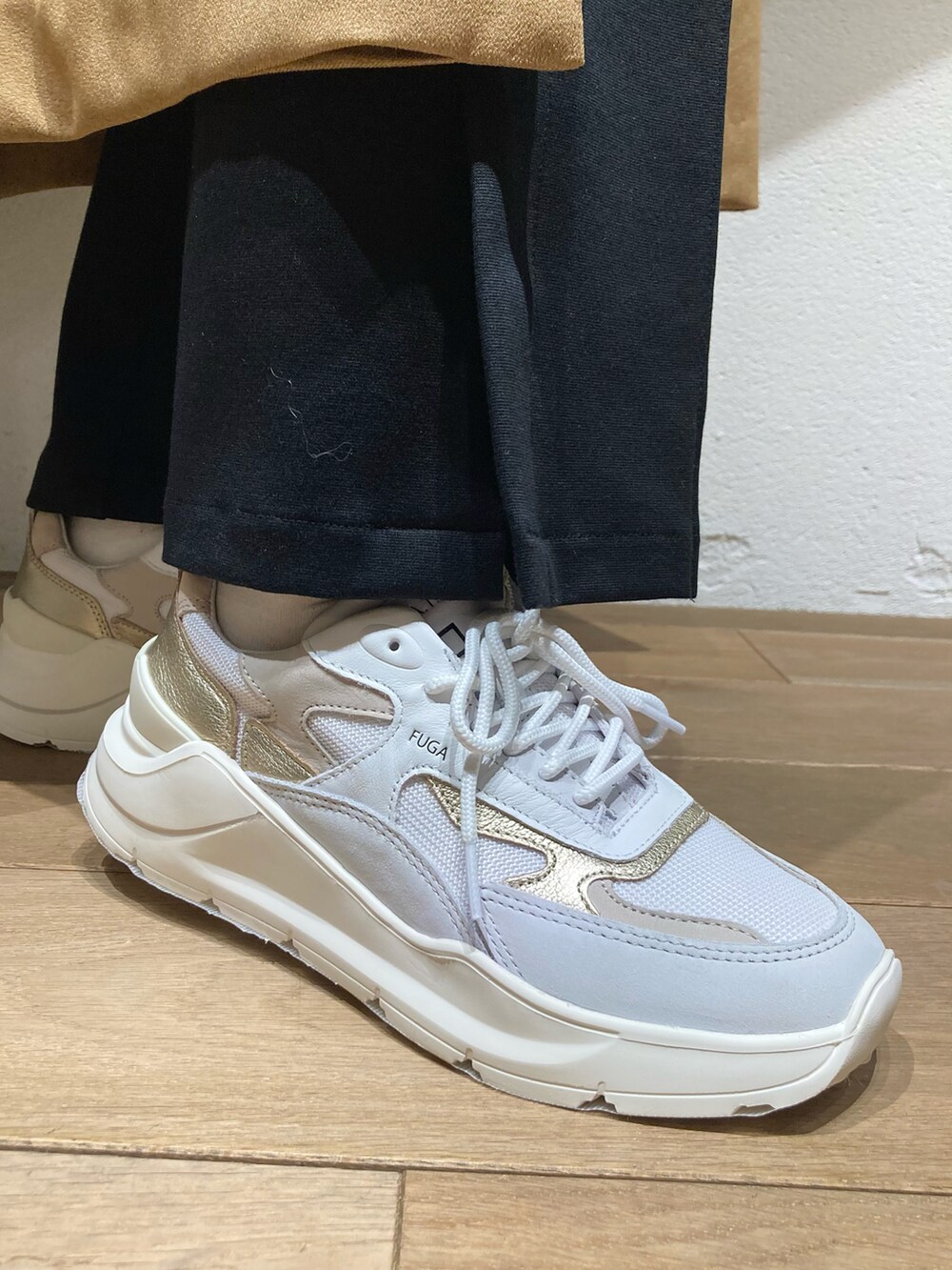 ホワイト系のニット/セーター、ベージュ系のベスト、ブラック系のパンツを着用したレディースの冬コーディネートの3枚目の写真