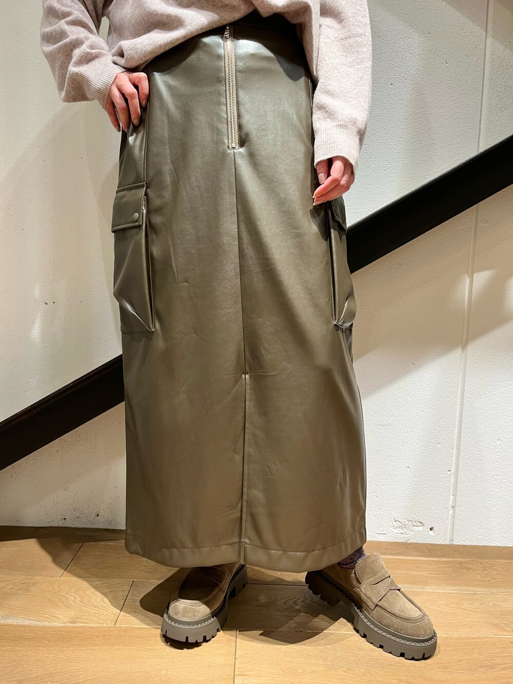 ブラック系のハンドバッグ、ホワイト系のピーコート、ベージュ系のニット/セーターを着用したレディースの冬コーディネートの3枚目の写真