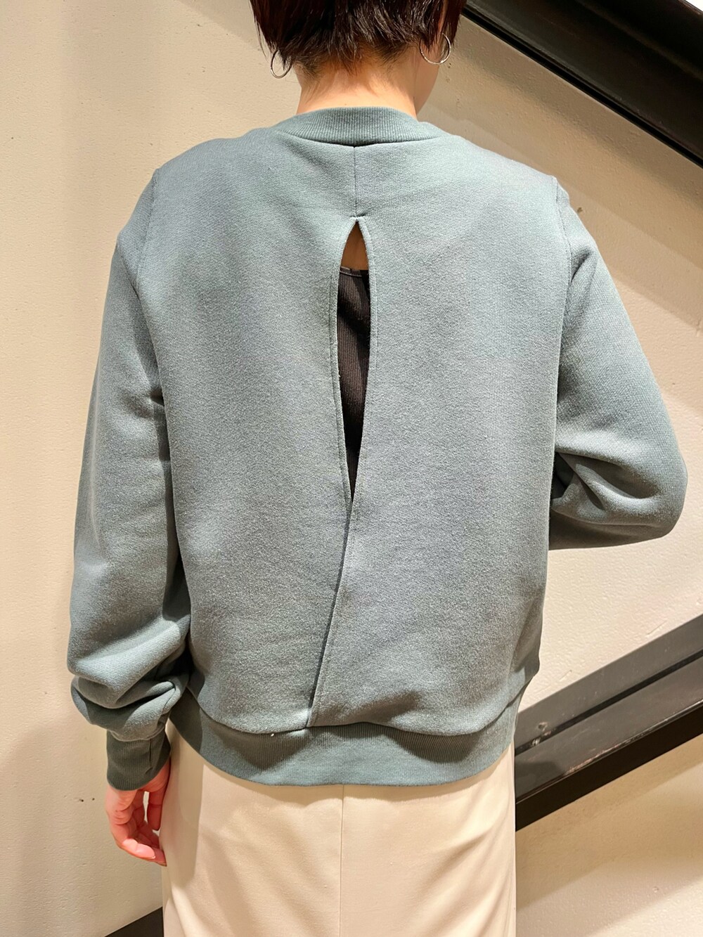 ブラック系のハンドバッグ、グリーン系のスウェット、ホワイト系のスカートを着用したレディースの春コーディネートの4枚目の写真