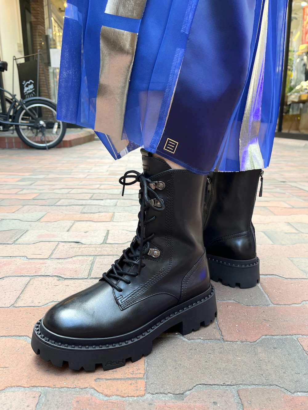 グレー系のTシャツ/カットソー、ブラック系のハンドバッグ、ブルー系のスカートを着用したレディースの秋コーディネートの5枚目の写真