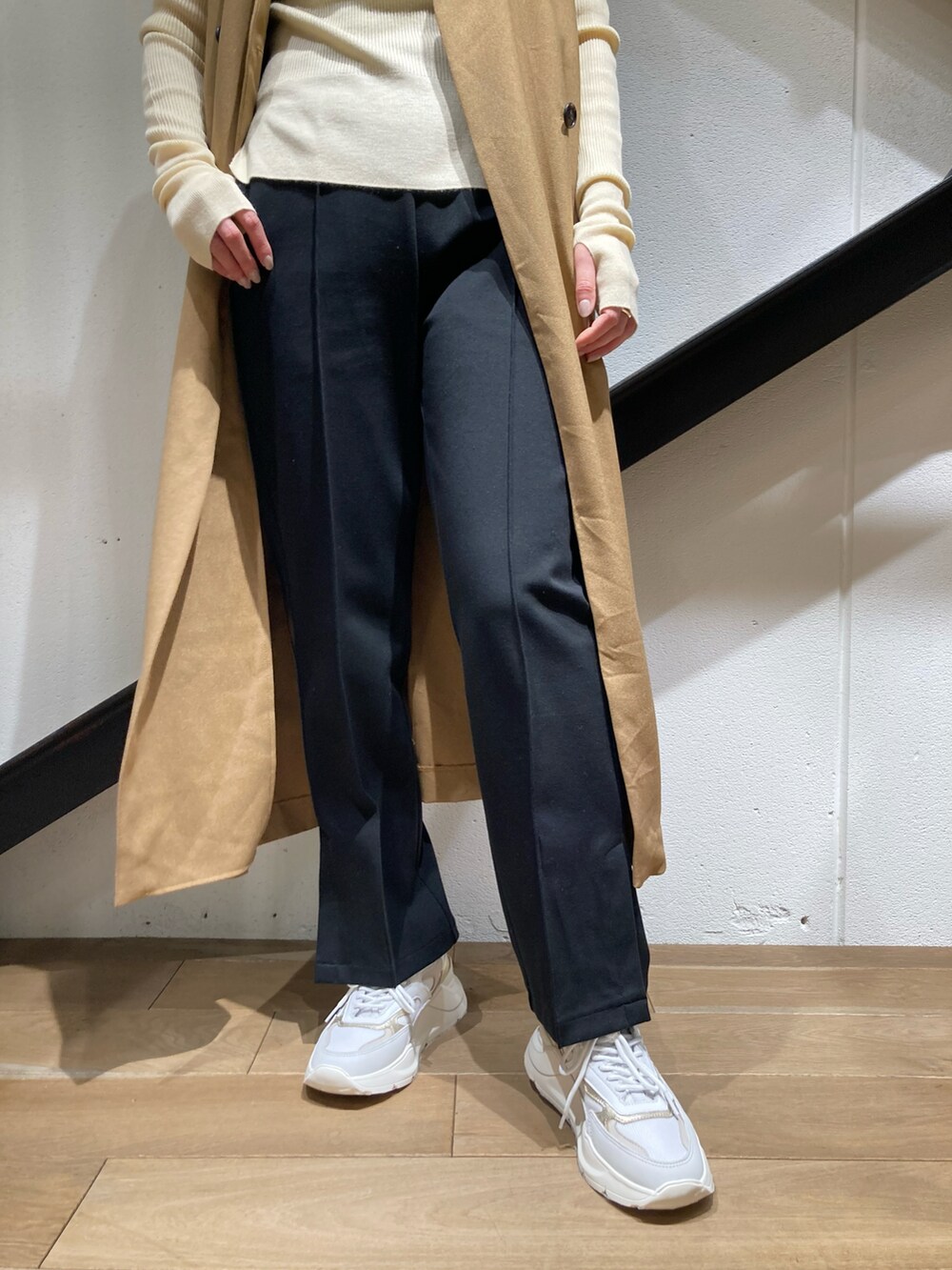 ホワイト系のニット/セーター、ベージュ系のベスト、ブラック系のパンツを着用したレディースの冬コーディネートの2枚目の写真