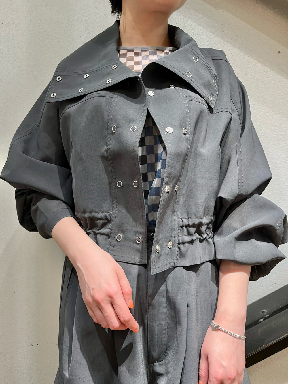 グレー系のナイロンジャケット、グレー系のカーゴパンツ、ブルー系のトップスを着用したレディースの春コーディネートの3枚目の写真