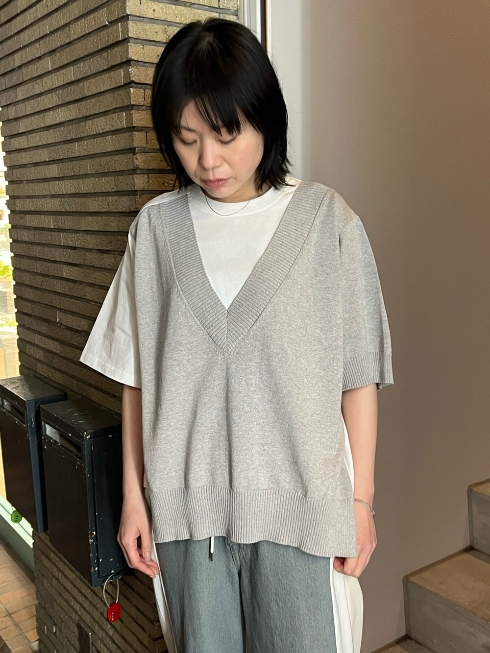 ベージュ系のMA-1、グレー系のTシャツ/カットソー、ブルー系のデニムパンツを着用したレディースの春コーディネートの3枚目の写真