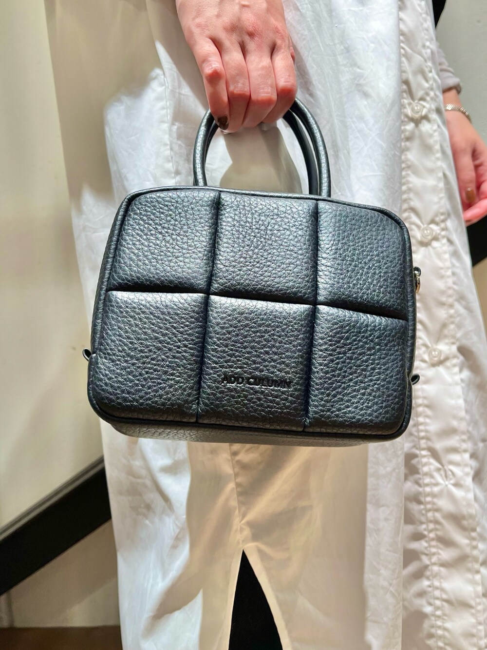 グレー系のスニーカー、ブラック系のハンドバッグを着用したレディースの秋コーディネートの3枚目の写真