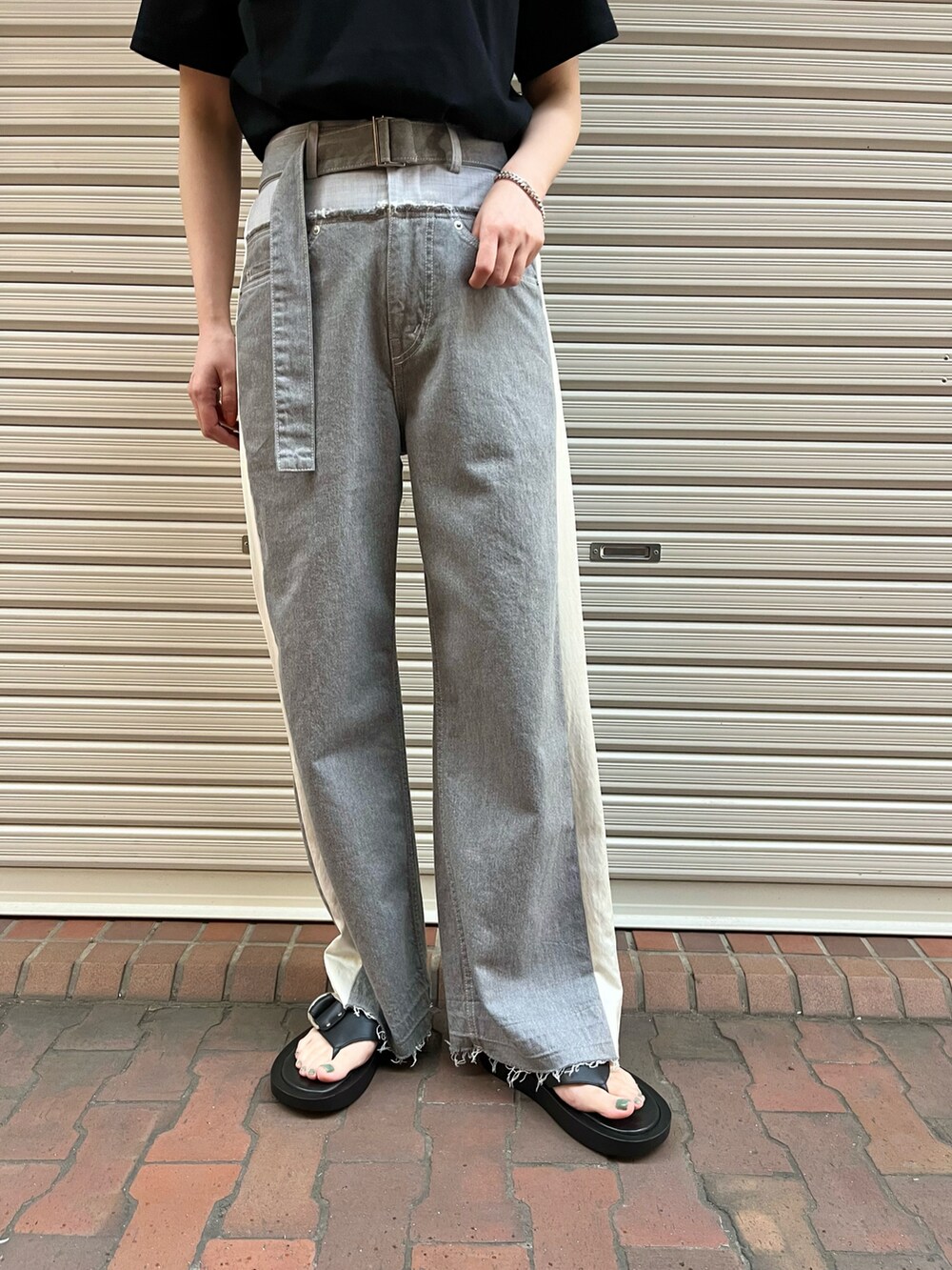 ブラック系のサンダル、グレー系のデニムパンツ、ブラック系のTシャツ/カットソーを着用したレディースの春コーディネートの2枚目の写真