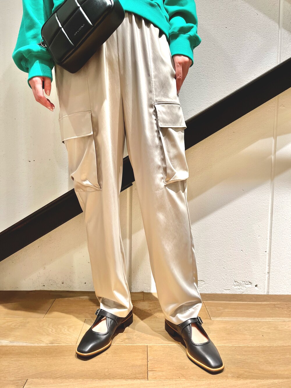 ブラック系のショルダーバッグ、グリーン系のスウェット、グレー系のパンツを着用したレディースの秋コーディネートの3枚目の写真