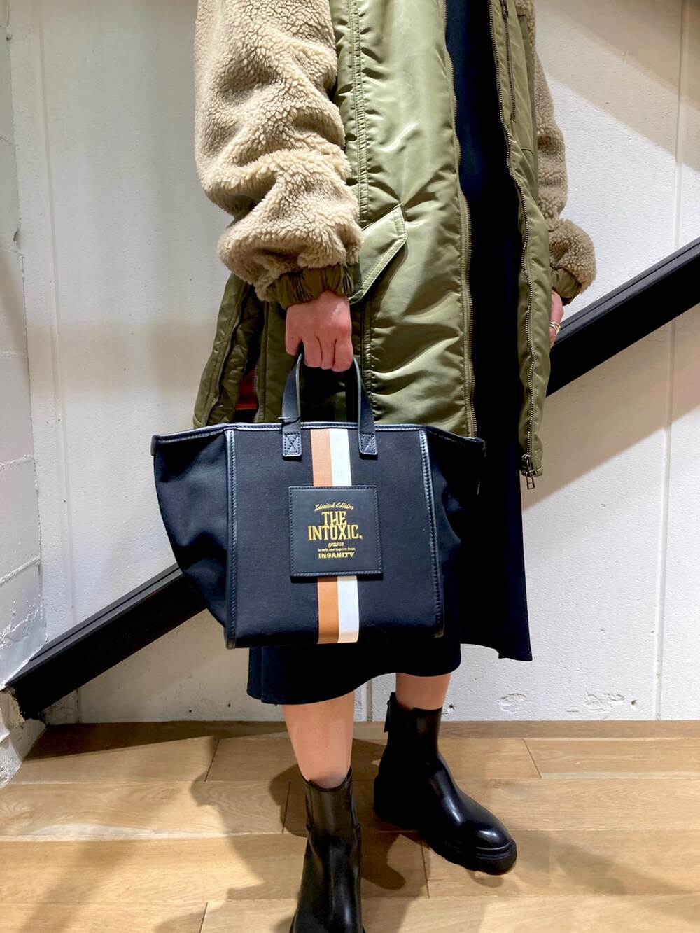 ブラック系のトートバッグ、ベージュ系のジャケット/アウター、ブラック系のワンピースを着用したレディースの秋コーディネートの2枚目の写真