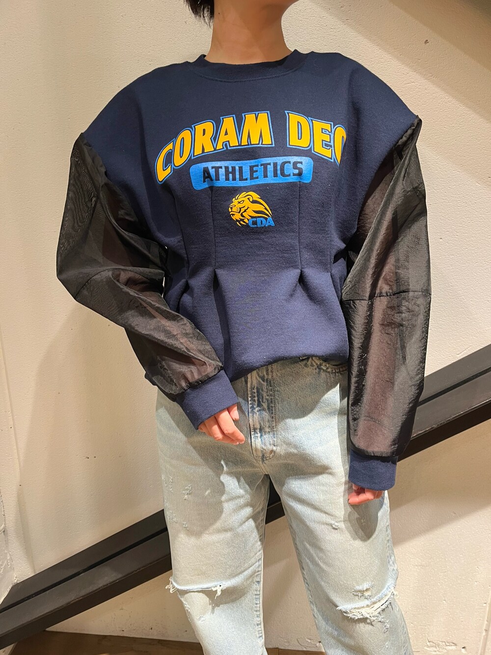 グレー系のショルダーバッグ、ブルー系のスウェット、ブルー系のデニムパンツを着用したレディースの春コーディネートの3枚目の写真