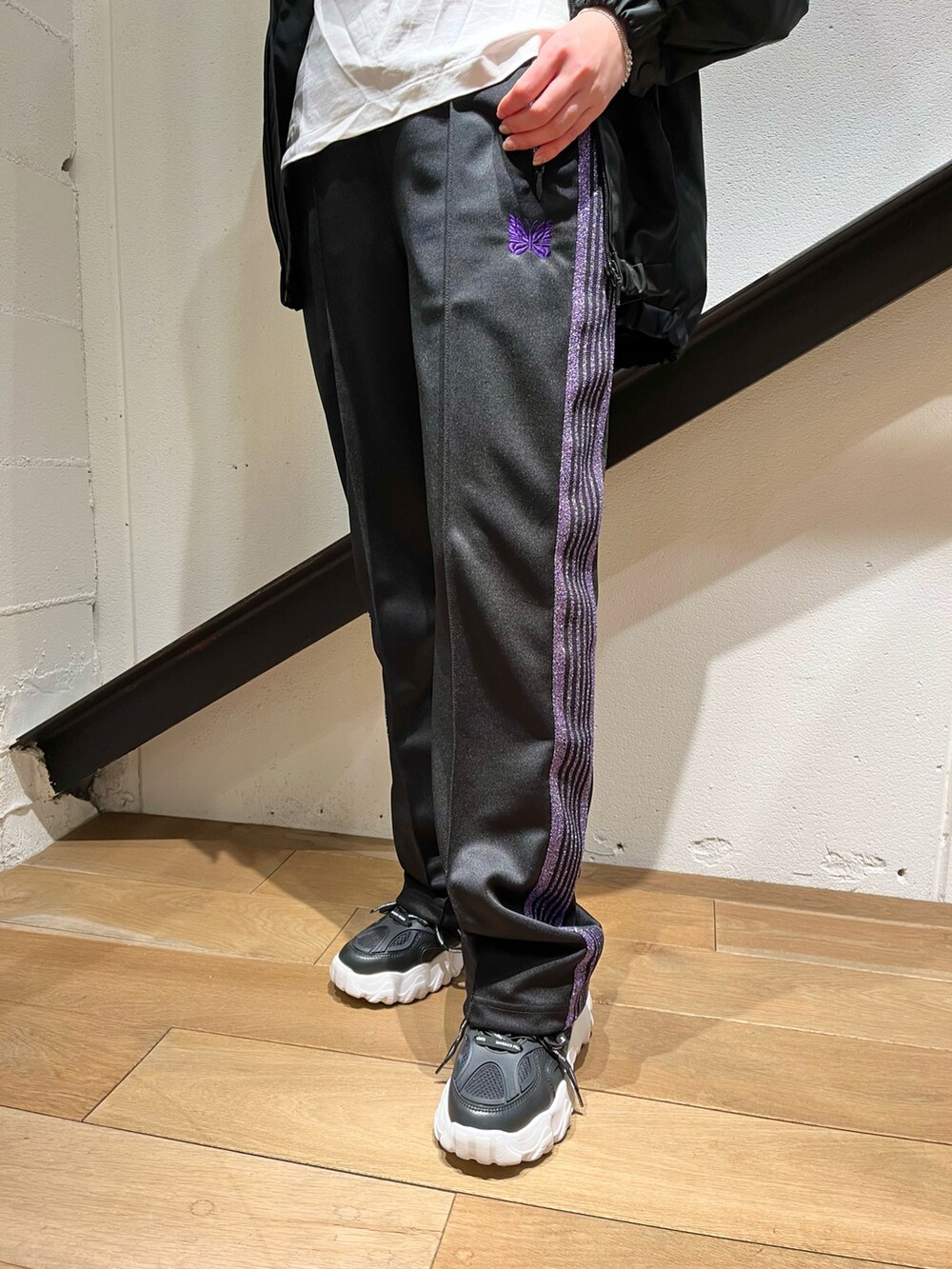 ブラック系のブルゾン、グリーン系のパンツ、ブラック系のスニーカーを着用したレディースの冬コーディネートの2枚目の写真