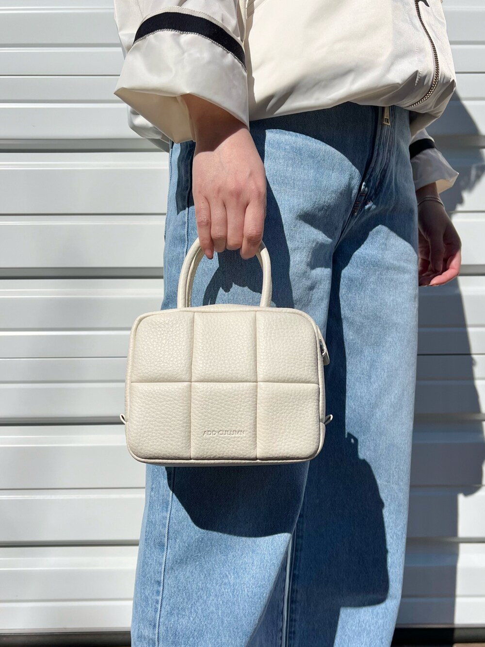 ホワイト系のハンドバッグ、その他のデニムパンツ、ホワイト系のジャケット/アウターを着用したレディースの春コーディネートの2枚目の写真