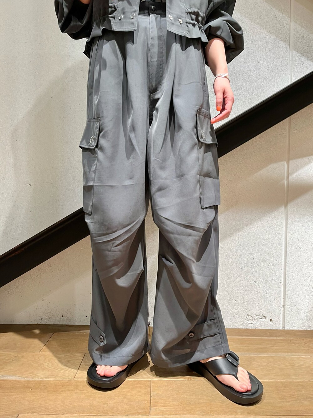 グレー系のナイロンジャケット、グレー系のカーゴパンツ、ブルー系のトップスを着用したレディースの春コーディネートの2枚目の写真