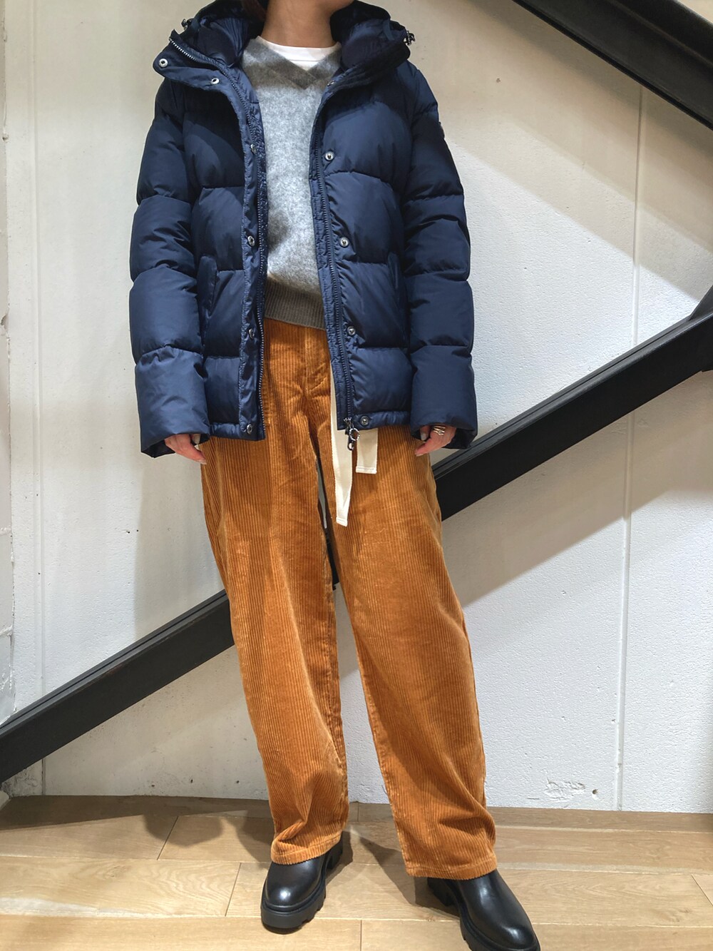 ブルー系のダウンジャケット/コート、グレー系のニット/セーター、イエロー系のその他パンツを着用したレディースの秋コーディネートの2枚目の写真