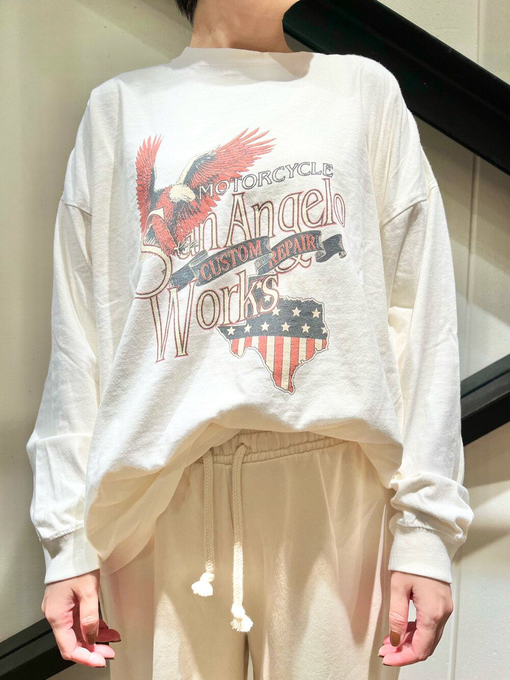 グレー系のショルダーバッグ、ホワイト系のTシャツ/カットソー、グレー系のスニーカーを着用したレディースの秋コーディネートの3枚目の写真