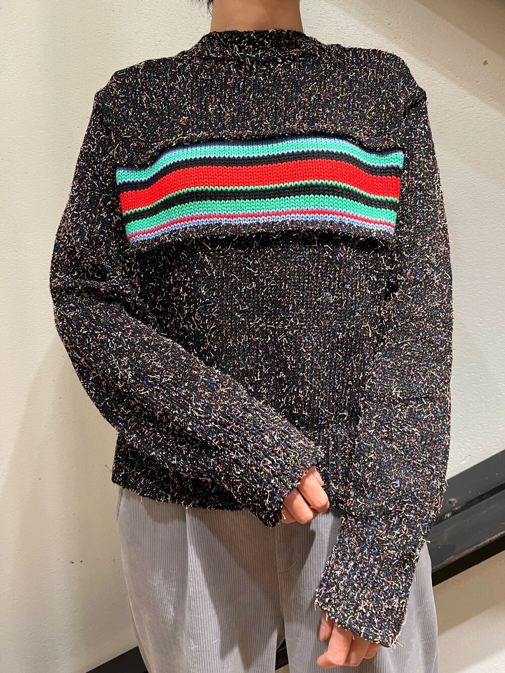 グレー系のショルダーバッグ、ブラック系のダウンジャケット/コート、ブラック系のニット/セーターを着用したレディースの冬コーディネートの4枚目の写真