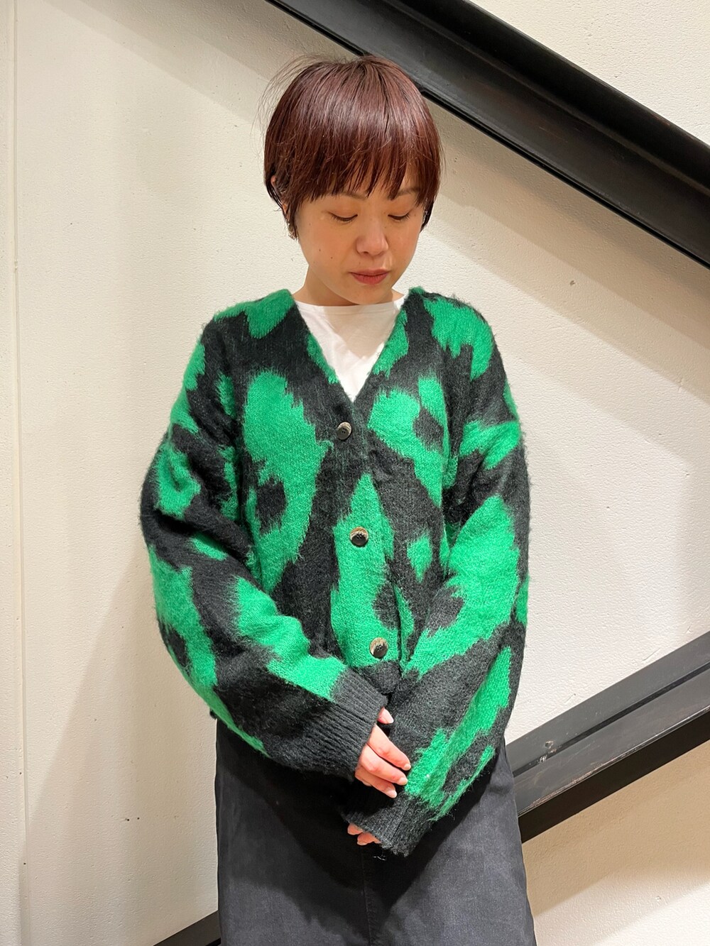 ブラック系のショルダーバッグ、ブラック系のカーディガン/ボレロ、ブラック系のスカートを着用したレディースの秋コーディネートの3枚目の写真