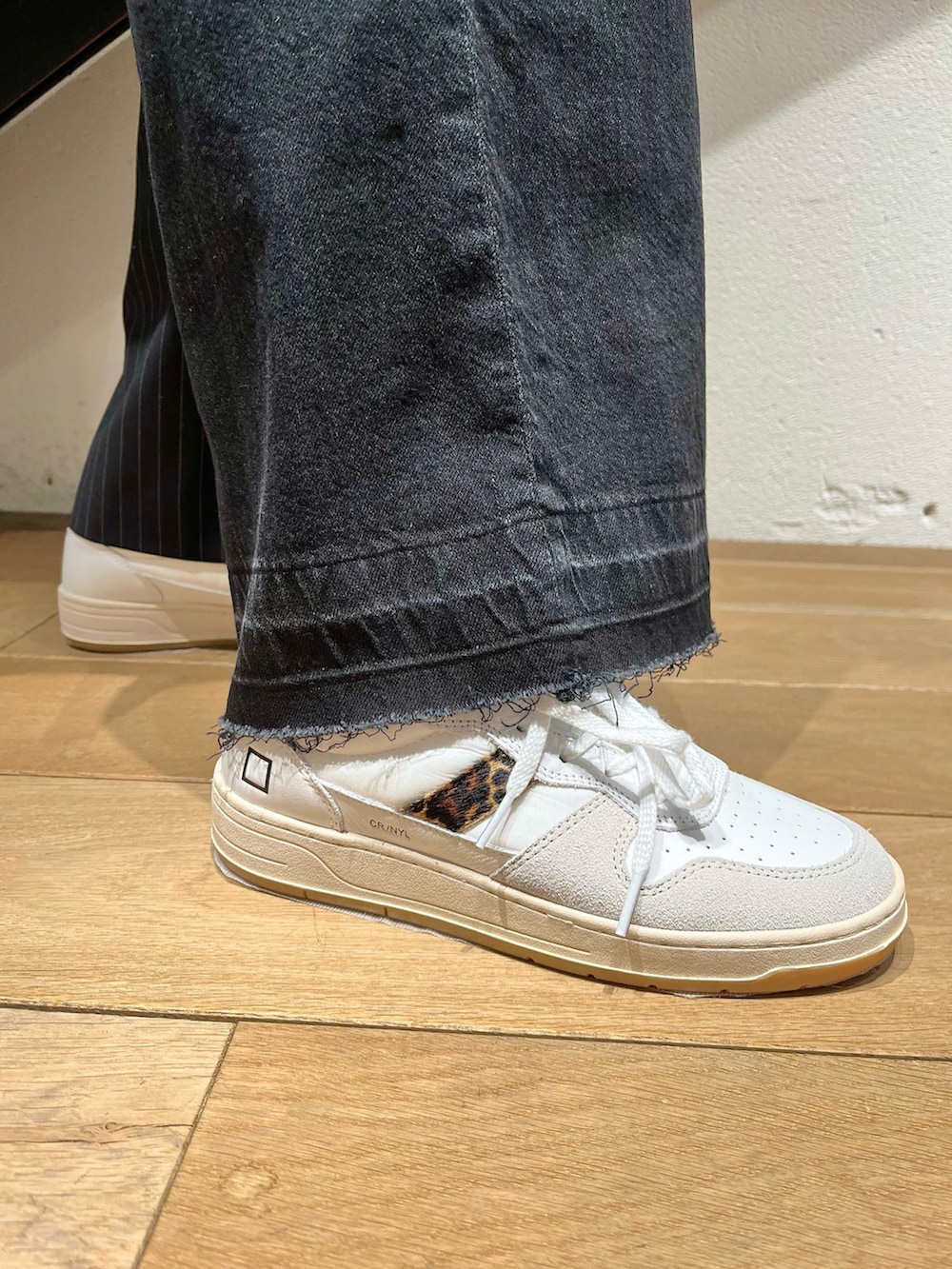 ブルー系のトップス、グレー系のベスト、ブラック系のバッグを着用したレディースの春コーディネートの2枚目の写真