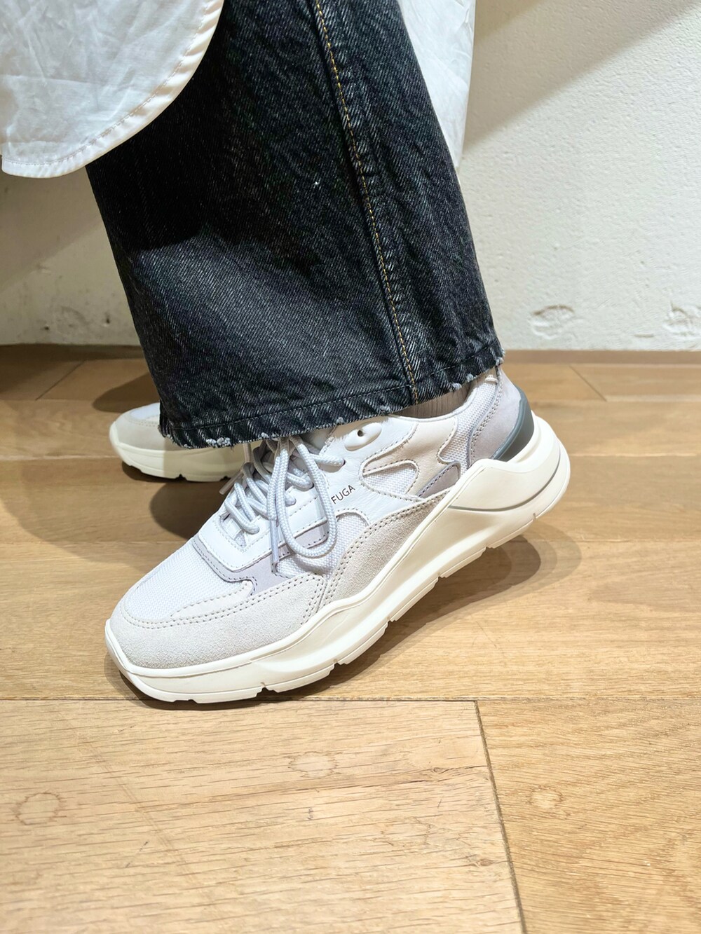 グレー系のスニーカー、ブラック系のハンドバッグを着用したレディースの秋コーディネートの4枚目の写真