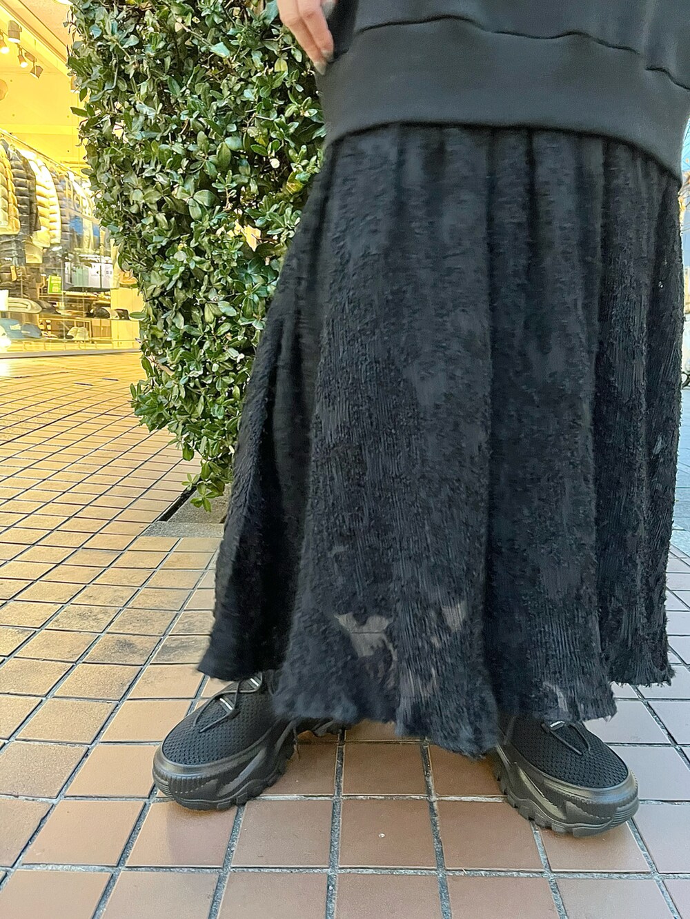 ブラック系のショルダーバッグ、ブラック系のワンピース、ブラック系のスニーカーを着用したレディースの冬コーディネートの5枚目の写真