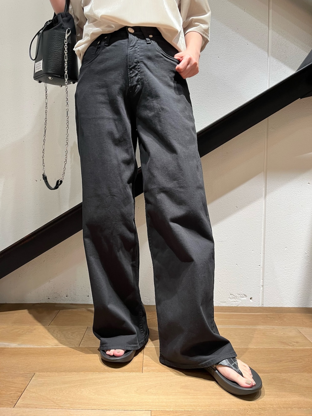 ベージュ系のTシャツ/カットソー、ブラック系のサンダル、ブラック系のデニムパンツを着用したレディースの夏コーディネートの3枚目の写真