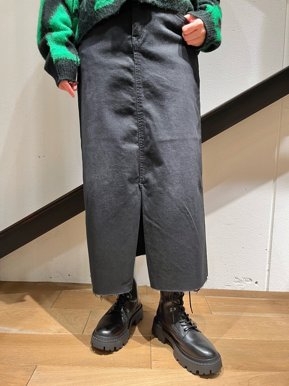 ブラック系のショルダーバッグ、ブラック系のカーディガン/ボレロ、ブラック系のスカートを着用したレディースの秋コーディネートの4枚目の写真