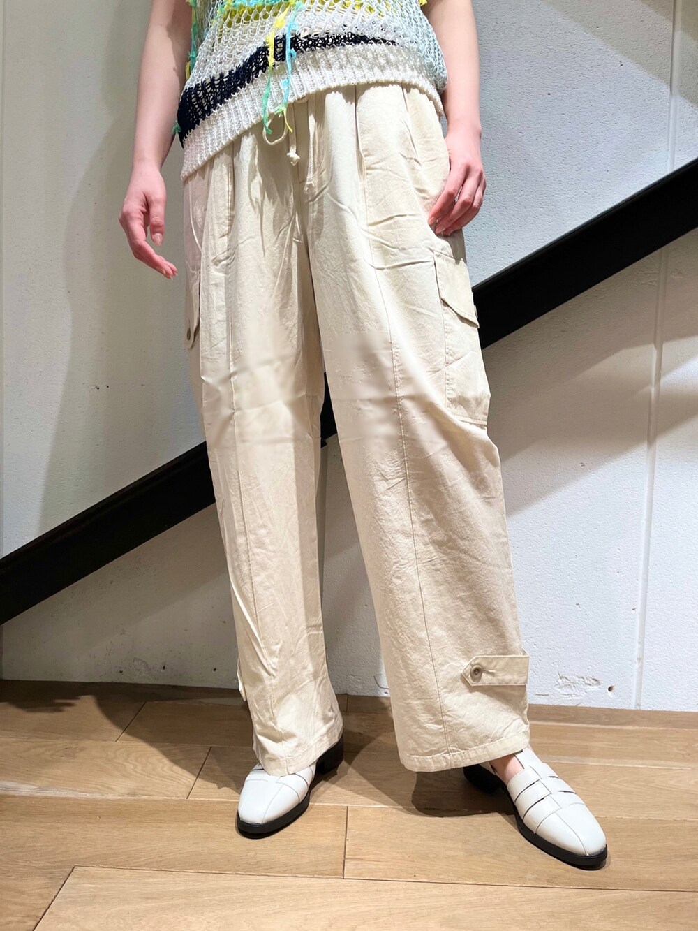 ホワイト系のニット/セーター、グリーン系のショルダーバッグ、ホワイト系のカーゴパンツを着用したレディースの夏コーディネートの2枚目の写真