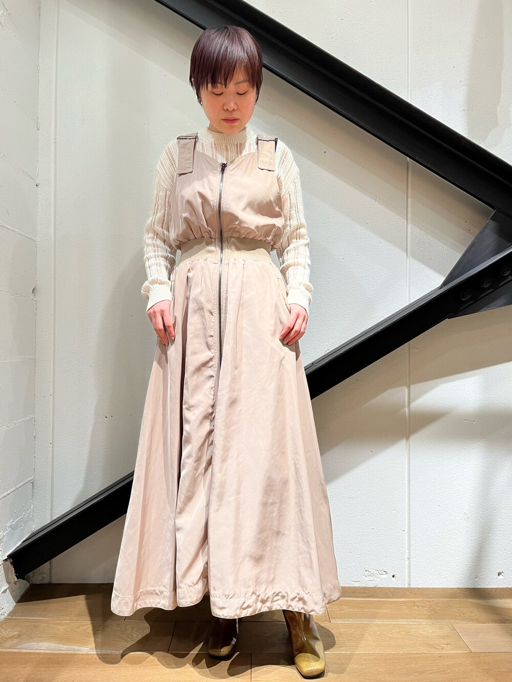 ブルー系のジャケット/アウター、ベージュ系のワンピース、オレンジ系のブーツを着用したレディースの冬コーディネートの2枚目の写真