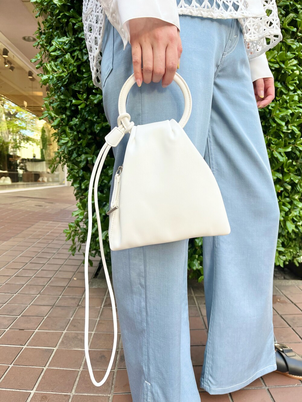 ホワイト系のシャツ/ブラウス、ホワイト系のショルダーバッグ、ブルー系のパンツを着用したレディースの春コーディネートの3枚目の写真