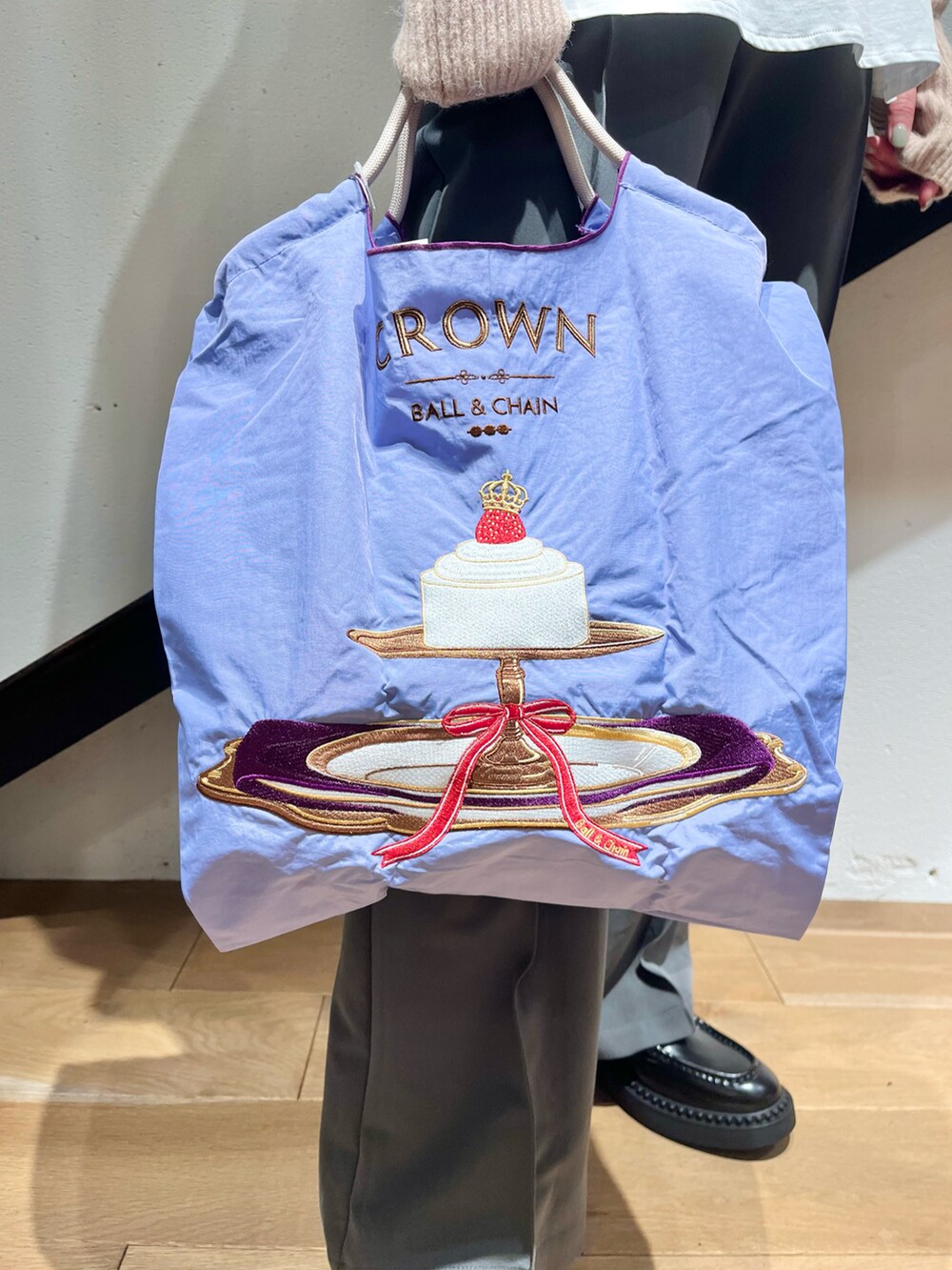 ピンク系のニット/セーター、ホワイト系のTシャツ/カットソー、パープル系のエコバッグ/サブバッグを着用したレディースの冬コーディネートの5枚目の写真