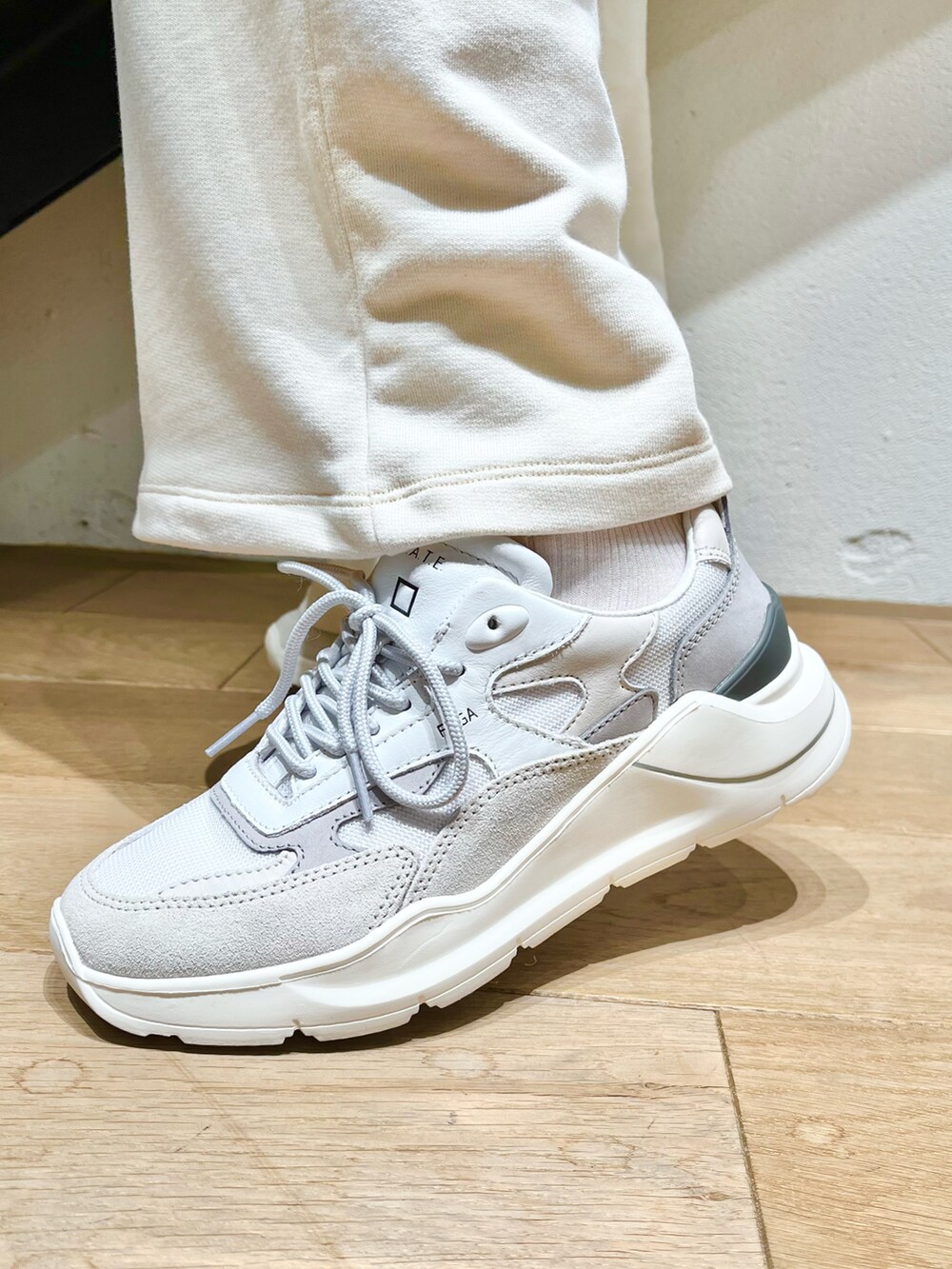 グレー系のショルダーバッグ、ホワイト系のTシャツ/カットソー、グレー系のスニーカーを着用したレディースの秋コーディネートの4枚目の写真