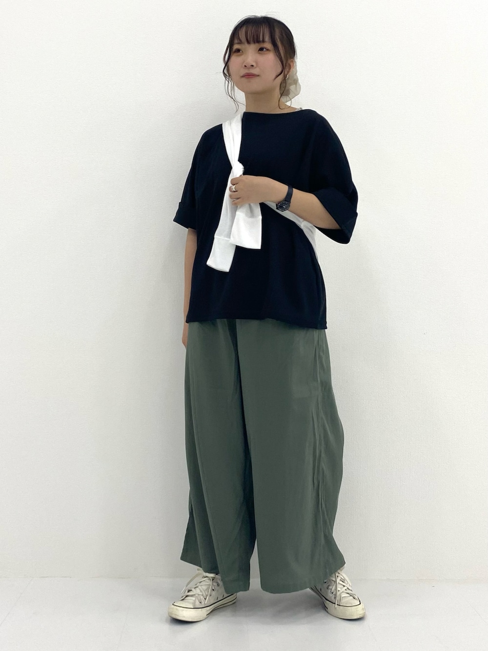 ブラック系のトップス、ブルー系のパンツ、ホワイト系のパーカーを着用したレディースの秋コーディネートの2枚目の写真