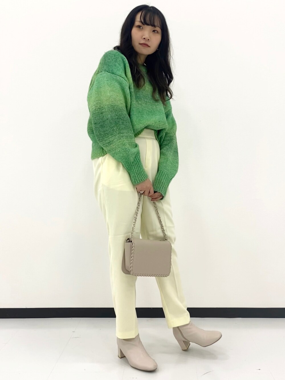 グリーン系のトップスを着用したレディースの春コーディネートの2枚目の写真