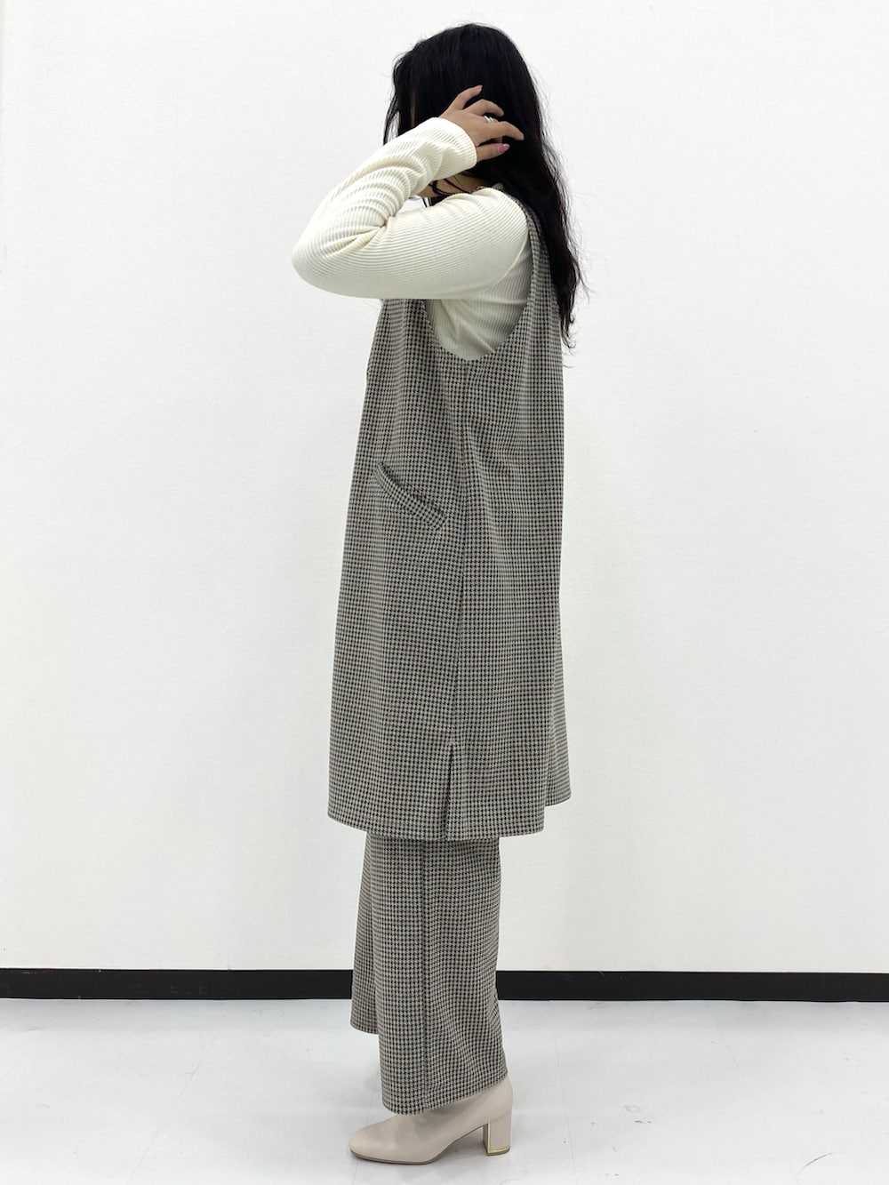 ホワイト系のトップス、グレー系のパンツ、グレー系のトップスを着用したレディースの冬コーディネートの3枚目の写真