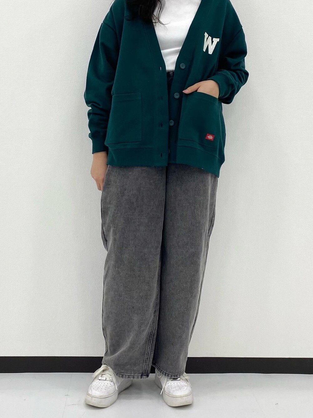 ホワイト系のトップス、グリーン系のトップス、ブラック系のパンツを着用したレディースの秋コーディネートの2枚目の写真