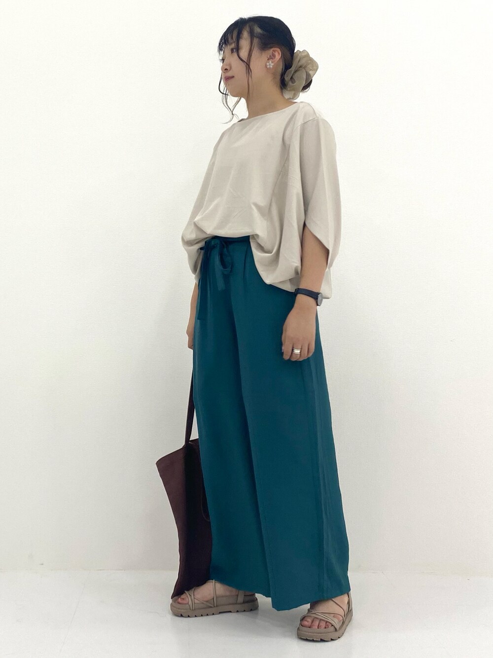 ホワイト系のトップス、グリーン系のパンツを着用したレディースの秋コーディネートの2枚目の写真